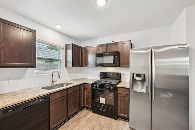 852 Rd 5138, Cleveland, TX 77327 - kitchen featuring black appliances, light wood finished floors, dark brown cabinetry, and light stone counters