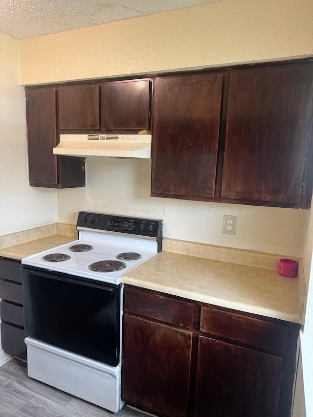 5664 Birchmont Dr Unit 4, Houston, TX 77091 - kitchen featuring white electric range, under cabinet range hood, light countertops, dark brown cabinetry, and a textured ceiling