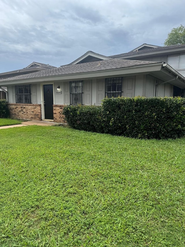 5664 Birchmont Dr Unit 4, Houston, TX 77091 - view of front facade with brick siding, a front lawn, board and batten siding, and a shingled roof