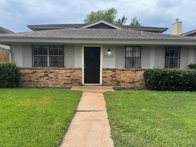 5664 Birchmont Dr Unit 4, Houston, TX 77091 - view of front facade featuring brick siding, a front lawn, roof with shingles, and a chimney