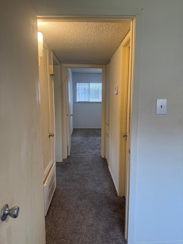 5664 Birchmont Dr Unit 4, Houston, TX 77091 - hallway featuring dark colored carpet and a textured ceiling