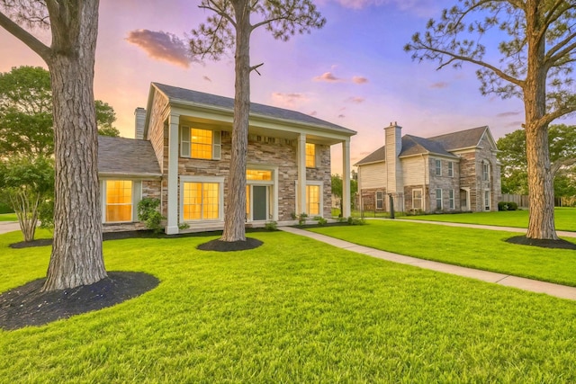 10410 Dude Rd, Houston, TX 77064 - back of property at dusk featuring stone siding, a lawn, and a chimney