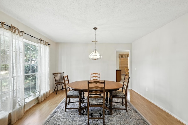 10410 Dude Rd, Houston, TX 77064 - dining area with light wood-type flooring, a textured ceiling, and a chandelier