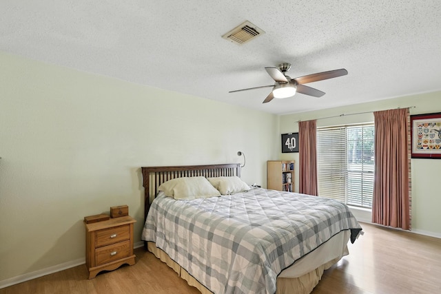 10410 Dude Rd, Houston, TX 77064 - bedroom featuring light wood-type flooring, a textured ceiling, and a ceiling fan