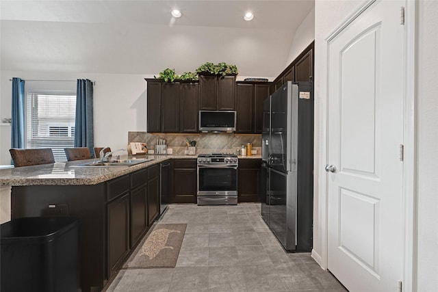 15023 Winter Valley Ct, Humble, TX 77396 - kitchen with stainless steel appliances, tasteful backsplash, dark brown cabinets, a peninsula, and recessed lighting