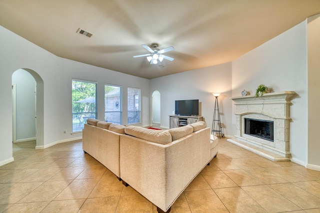 519 Ivory Stone Ln, League City, TX 77573 - living area with light tile patterned flooring, a high end fireplace, arched walkways, and a ceiling fan