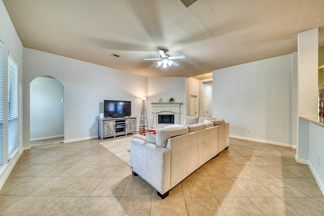 519 Ivory Stone Ln, League City, TX 77573 - living area with a ceiling fan, arched walkways, a fireplace with raised hearth, and light tile patterned floors