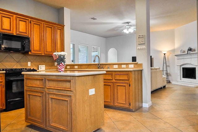 519 Ivory Stone Ln, League City, TX 77573 - kitchen with black appliances, a ceiling fan, light tile patterned floors, tasteful backsplash, and light countertops