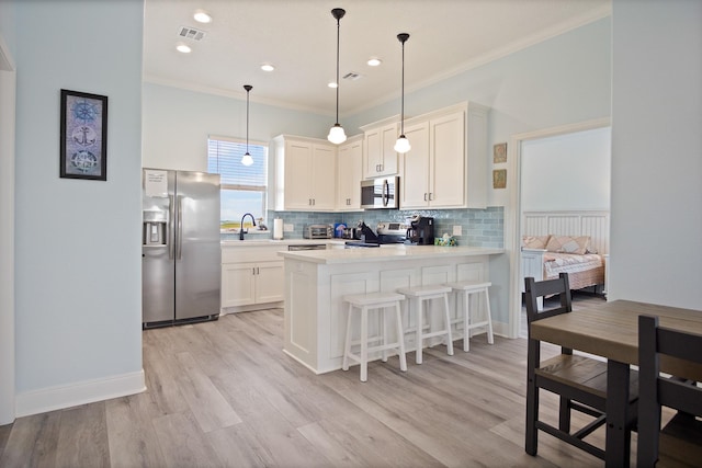 1229 N Stingaree Dr, Crystal Beach, TX 77650 - kitchen with appliances with stainless steel finishes, a peninsula, decorative backsplash, light countertops, and crown molding