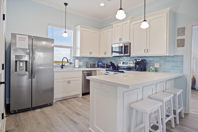 1229 N Stingaree Dr, Crystal Beach, TX 77650 - kitchen with appliances with stainless steel finishes, ornamental molding, a peninsula, light wood-style floors, and light countertops
