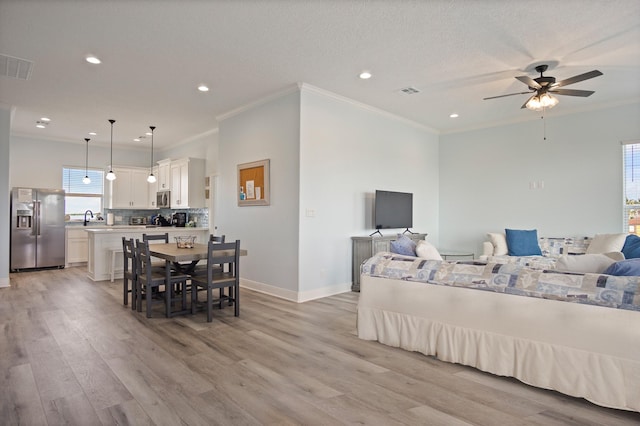 1229 N Stingaree Dr, Crystal Beach, TX 77650 - living room featuring light wood finished floors, crown molding, recessed lighting, and a ceiling fan