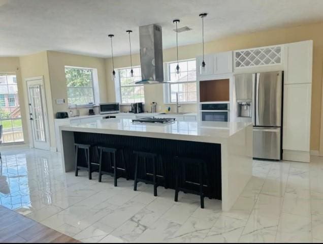 20522 Riverside Pines Dr, Houston, TX 77346 - kitchen featuring island range hood, stainless steel appliances, light marble finish flooring, and a spacious island