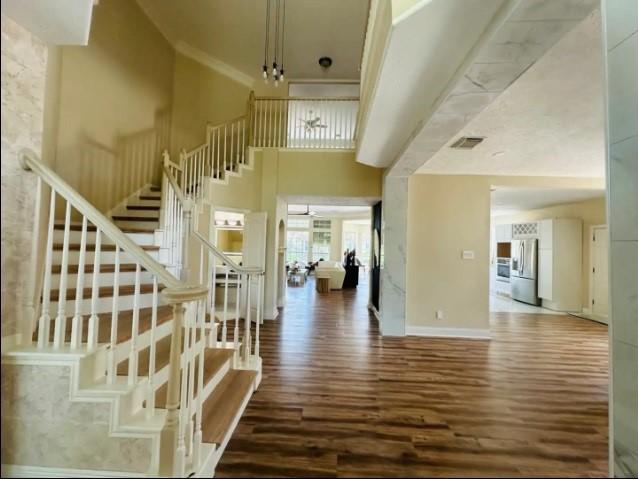 20522 Riverside Pines Dr, Houston, TX 77346 - staircase with wood finished floors, a high ceiling, and crown molding