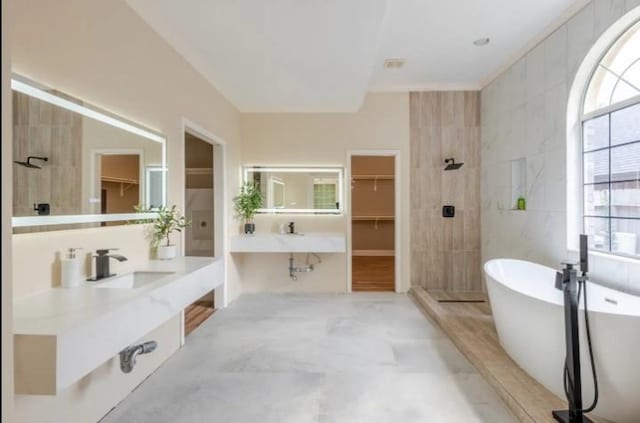 20522 Riverside Pines Dr, Houston, TX 77346 - bathroom with a walk in closet, a soaking tub, and vanity