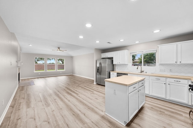 21002 Pineda Cir, Richmond, TX 77406 - kitchen with appliances with stainless steel finishes, a ceiling fan, light wood-style floors, a kitchen island, and light countertops