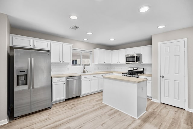 21002 Pineda Cir, Richmond, TX 77406 - kitchen featuring appliances with stainless steel finishes, light countertops, backsplash, white cabinetry, and recessed lighting