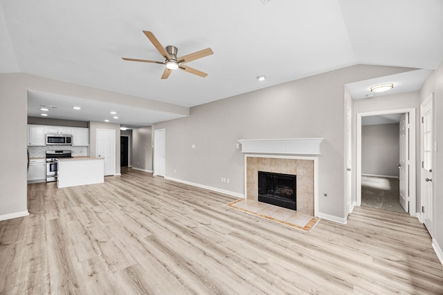 21002 Pineda Cir, Richmond, TX 77406 - unfurnished living room featuring ceiling fan, vaulted ceiling, light wood-style floors, a fireplace, and recessed lighting