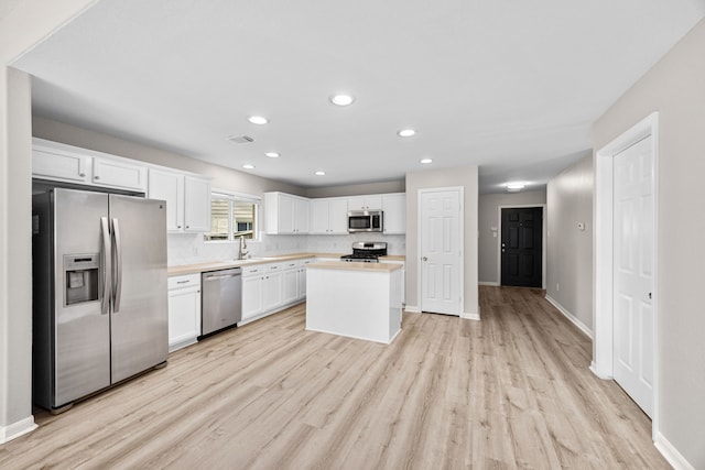 21002 Pineda Cir, Richmond, TX 77406 - kitchen with appliances with stainless steel finishes, light wood-type flooring, light countertops, white cabinets, and recessed lighting