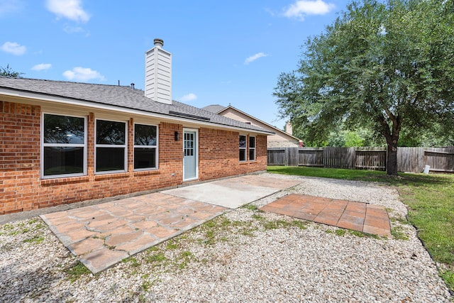 21002 Pineda Cir, Richmond, TX 77406 - back of house with a fenced backyard, a patio, brick siding, and a chimney