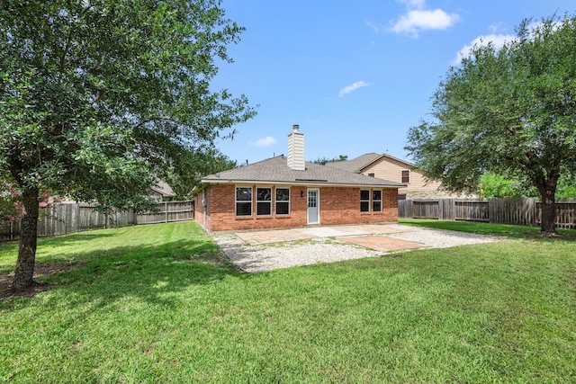 21002 Pineda Cir, Richmond, TX 77406 - back of property with a chimney, a patio area, a fenced backyard, brick siding, and roof with shingles