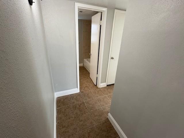 12127 Rhinebeck Dr, Houston, TX 77089 - hall with dark tile patterned floors and a textured wall