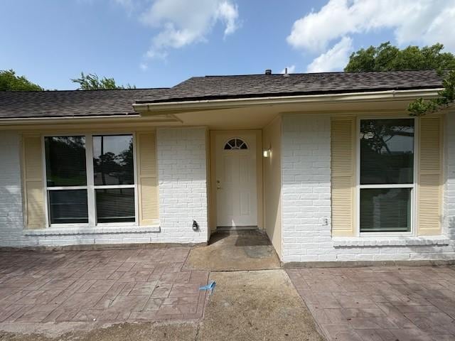 12127 Rhinebeck Dr, Houston, TX 77089 - view of exterior entry with brick siding and a shingled roof