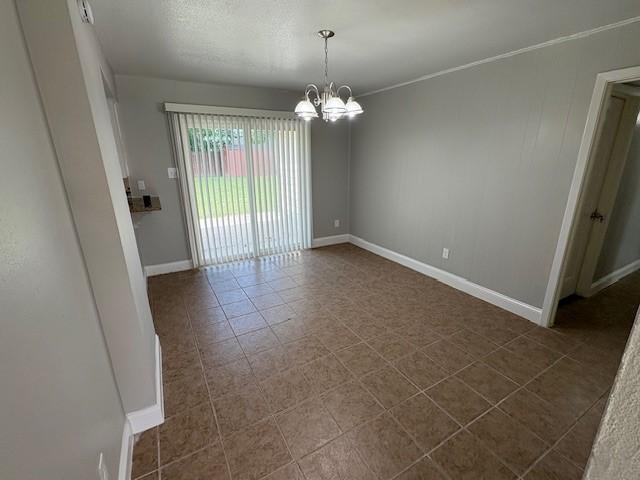 12127 Rhinebeck Dr, Houston, TX 77089 - spare room featuring a chandelier and dark tile patterned floors