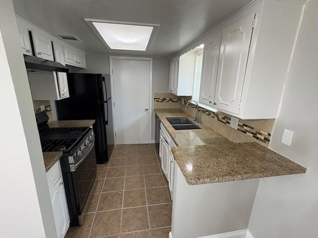 12127 Rhinebeck Dr, Houston, TX 77089 - kitchen with range with gas stovetop, under cabinet range hood, decorative backsplash, and white cabinetry