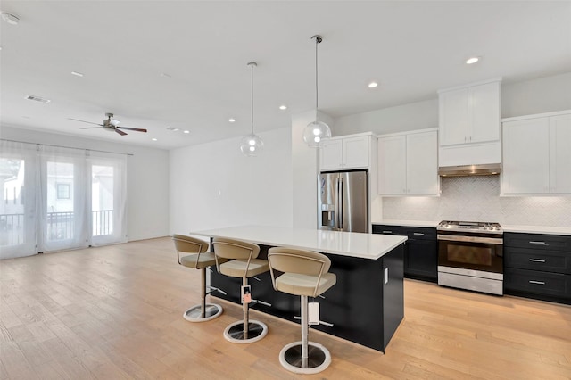 1740 Ojeman Point Ln, Houston, TX 77055 - kitchen with stainless steel appliances, light countertops, backsplash, a kitchen breakfast bar, and a kitchen island