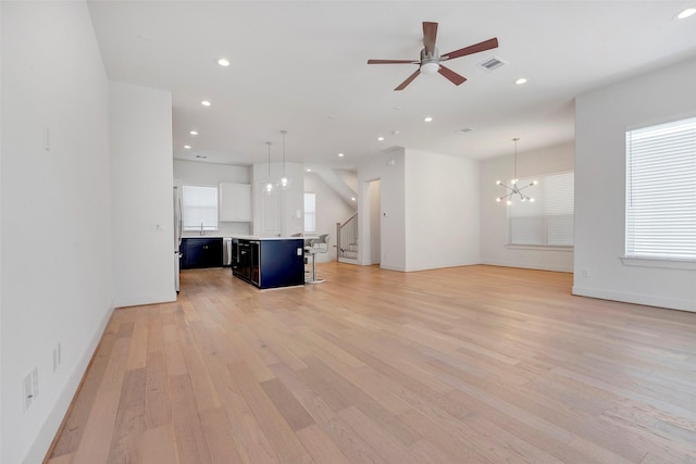 1740 Ojeman Point Ln, Houston, TX 77055 - unfurnished living room featuring light wood-style floors, recessed lighting, a chandelier, stairs, and ceiling fan