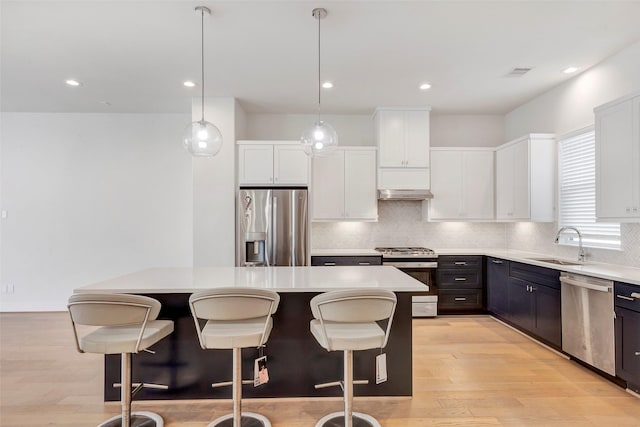 1740 Ojeman Point Ln, Houston, TX 77055 - kitchen with appliances with stainless steel finishes, backsplash, a center island, light countertops, and white cabinetry