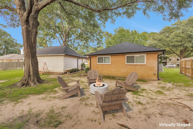 116 April Wind Dr E, Montgomery, TX 77356 - rear view of property with an outdoor fire pit, roof with shingles, and brick siding
