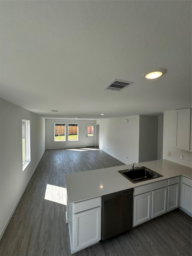 1611 Winwood Dr, Conroe, TX 77303 - kitchen featuring dishwasher, dark wood-type flooring, a peninsula, open floor plan, and a textured ceiling