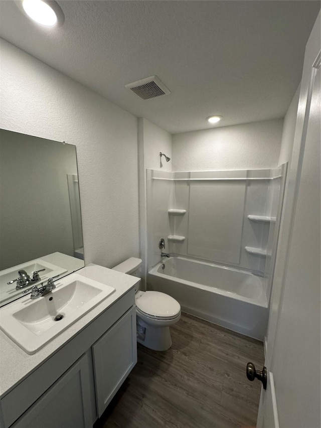 1611 Winwood Dr, Conroe, TX 77303 - full bathroom with wood finished floors, vanity, tub / shower combination, and a textured ceiling