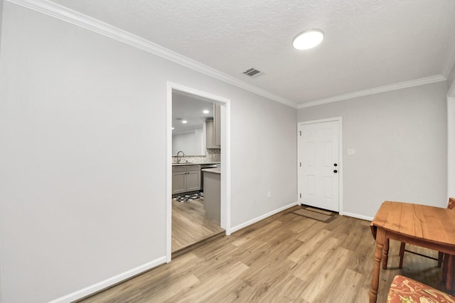 3603 Idaho St, Houston, TX 77021 - foyer with light wood-type flooring, crown molding, and a textured ceiling