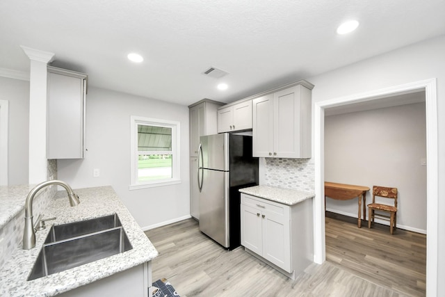 3603 Idaho St, Houston, TX 77021 - kitchen featuring freestanding refrigerator, light wood-style flooring, tasteful backsplash, light stone counters, and recessed lighting