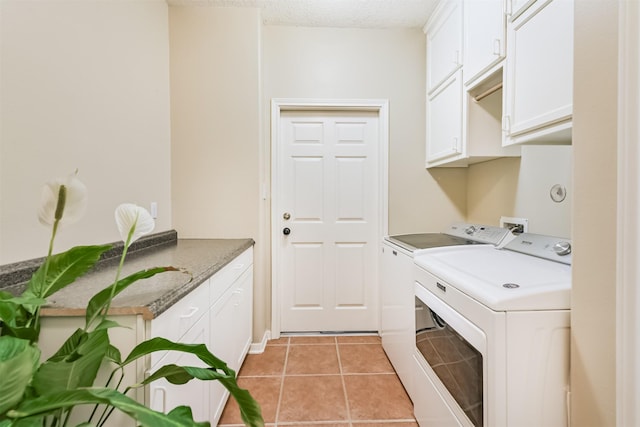 29218 Hay Meadow Ct, Waller, TX 77484 - laundry room featuring washing machine and dryer, cabinet space, light tile patterned floors, and a textured ceiling