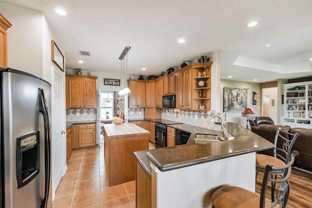 29218 Hay Meadow Ct, Waller, TX 77484 - kitchen with black appliances, open floor plan, a kitchen island, open shelves, and decorative backsplash