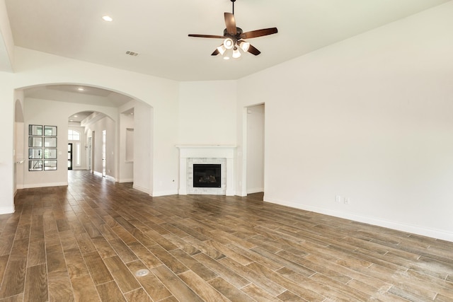 10318 Granite Ct, Iowa Colony, TX 77583 - unfurnished living room with ceiling fan, wood finished floors, recessed lighting, arched walkways, and a glass covered fireplace