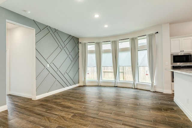 10318 Granite Ct, Iowa Colony, TX 77583 - unfurnished living room with dark wood finished floors, healthy amount of natural light, recessed lighting, and a decorative wall