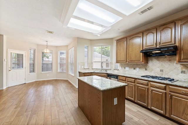 53 Silver Crescent Ct, The Woodlands, TX 77382 - kitchen featuring light wood-type flooring, appliances with stainless steel finishes, tasteful backsplash, a kitchen island, and a chandelier