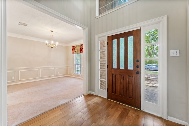 53 Silver Crescent Ct, The Woodlands, TX 77382 - entrance foyer featuring a chandelier, ornamental molding, wood finished floors, and wainscoting