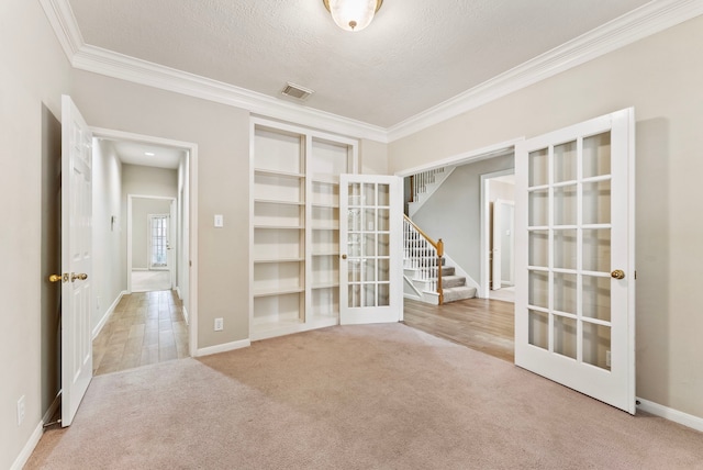 53 Silver Crescent Ct, The Woodlands, TX 77382 - carpeted spare room featuring ornamental molding, french doors, stairway, and a textured ceiling