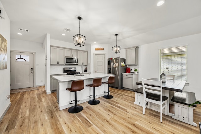 1618 William Scott St, Baytown, TX 77523 - kitchen featuring gray cabinetry, appliances with stainless steel finishes, a breakfast bar area, plenty of natural light, and recessed lighting