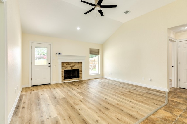 21 Alexander Ct, Angleton, TX 77515 - unfurnished living room featuring a ceiling fan, healthy amount of natural light, light wood-style flooring, lofted ceiling, and a stone fireplace