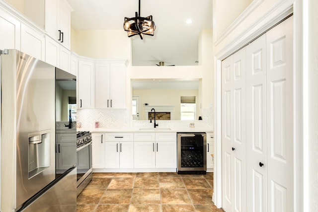 21 Alexander Ct, Angleton, TX 77515 - kitchen with stainless steel appliances, wine cooler, tasteful backsplash, and white cabinetry