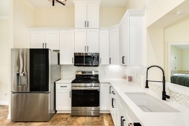 21 Alexander Ct, Angleton, TX 77515 - kitchen with stainless steel appliances, white cabinetry, decorative backsplash, and light stone counters
