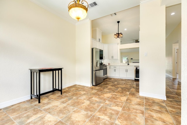 21 Alexander Ct, Angleton, TX 77515 - kitchen featuring appliances with stainless steel finishes, a chandelier, white cabinetry, wine cooler, and tasteful backsplash