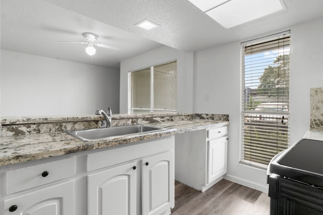 781 Country Place Dr Unit 2083, Houston, TX 77079 - kitchen with light wood-type flooring, white cabinets, a ceiling fan, stove, and a textured ceiling