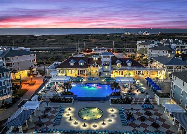 4121 Pointe W Dr Unit 103, Galveston, TX 77554 - aerial view at dusk of view of pool and a water view